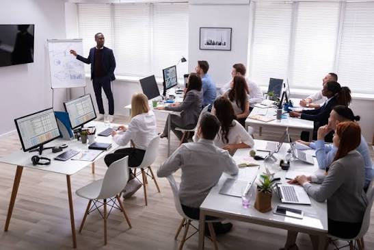 Session de formation en petit groupe : un formateur présente au paperboard devant des participants